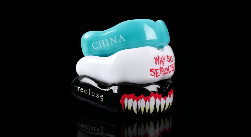 Custom sports mouthguards in teal, white and black with personalized text